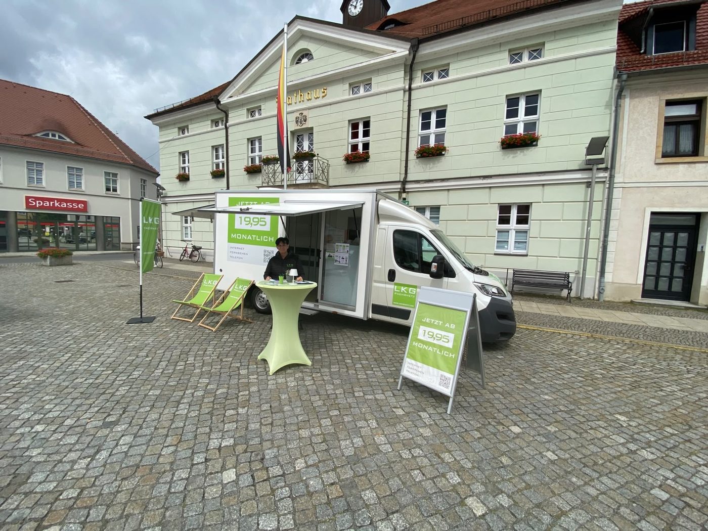 Das LKG-Infomobil mit Beratungsstand, Liegestühlen und Stehtisch auf einem Marktplatz